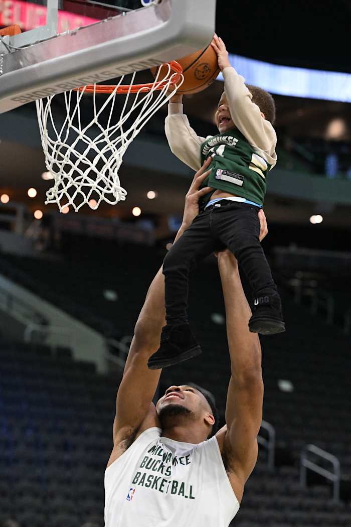 Milwaukee Bucks forward Giannis Antetokounmpo (34) lifts his middle son Maverick up to dunk